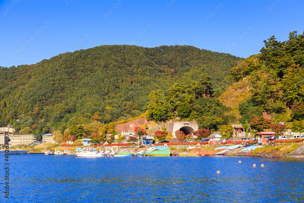Fototapeta premium Lake side road of Kawaguchi town, viewed from ferry, Kawaguchigo, Japan.