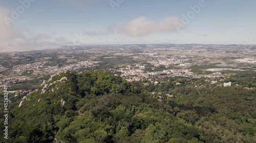 Orbiting shot above Sintra hills with Castelo dos Mouros on the edge overlooking serene landscape. photo