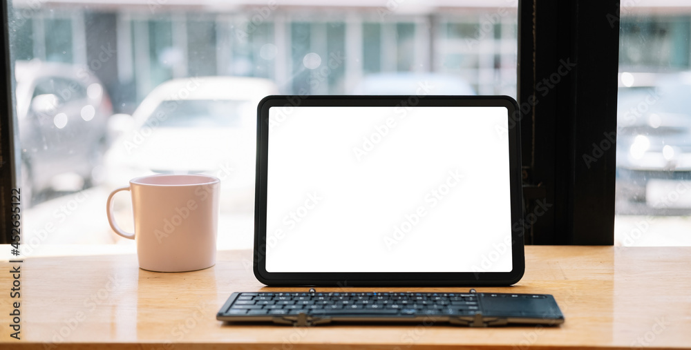 Shot of digital tablet with blank white screen, keyboard, cup of coffee on workspace desk Shot of digital tablet with blank white screen, keyboard, cup of coffee on workspace desk