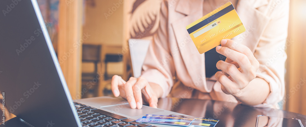 Woman paying online bills with credit card.She uses a laptop computer to search online.