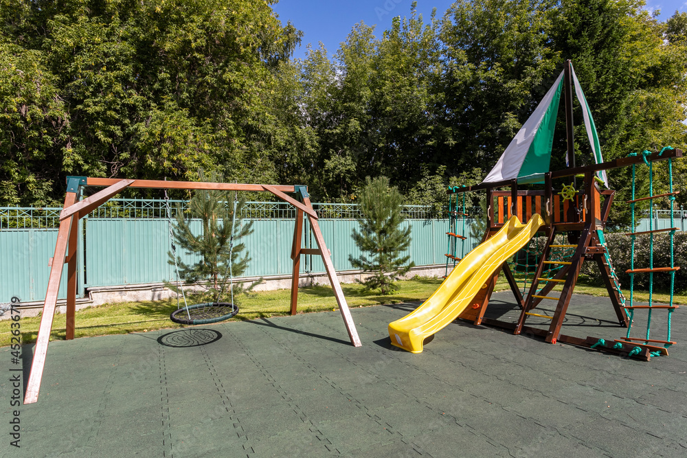 Empty playground for children for leisure and recreation with a toy in the park as a child in a natural style. Playground in a swing for mom and baby
