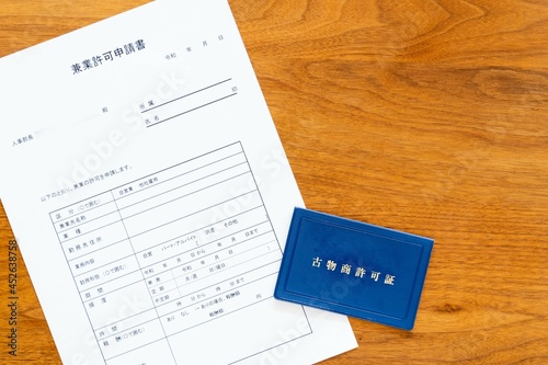 会社の人事部長宛てに作成する兼業許可申請書と副業でビジネスをするために取得した古物商許可書（左）