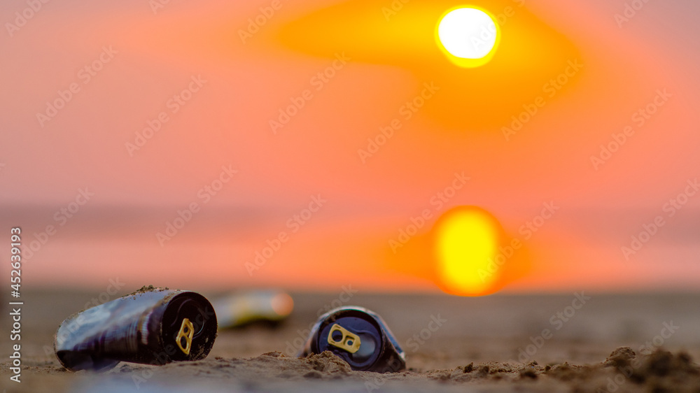 Garbage lying on a beach of a sea at sunset. Environmental pollution. Ecological problem. Empty space for text