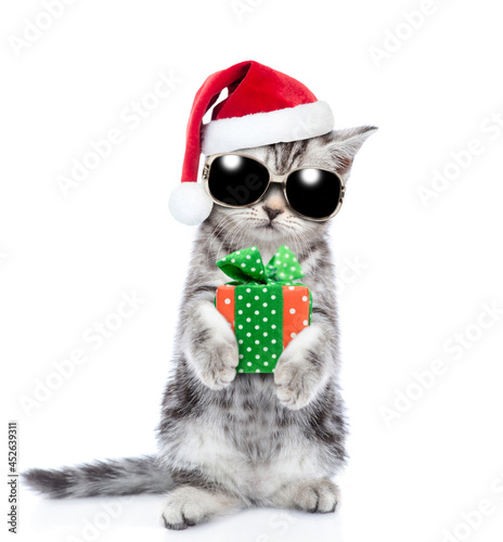 Tabby kitten wearing sunglasses and red christmas hat with gift box. isolated on white background