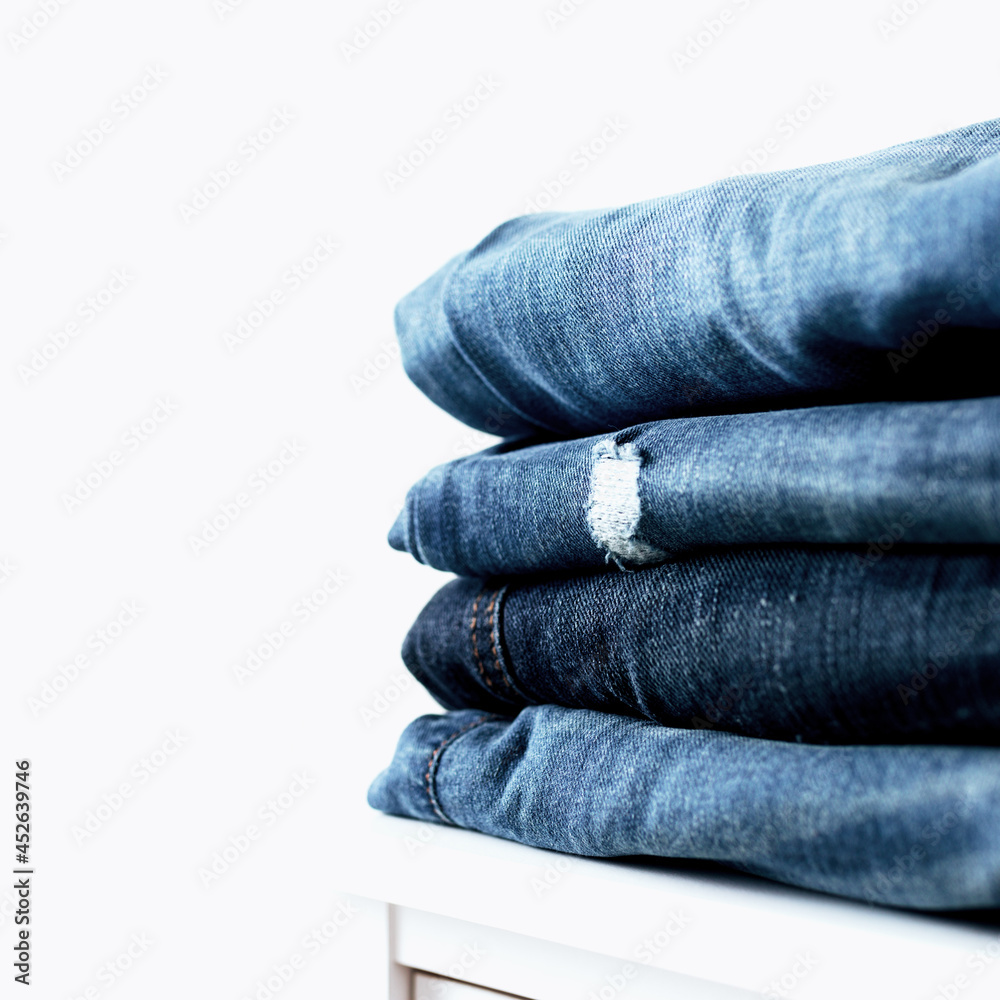 Stack of different jeans on the shelf or table Stack of different jeans on the shelf or table