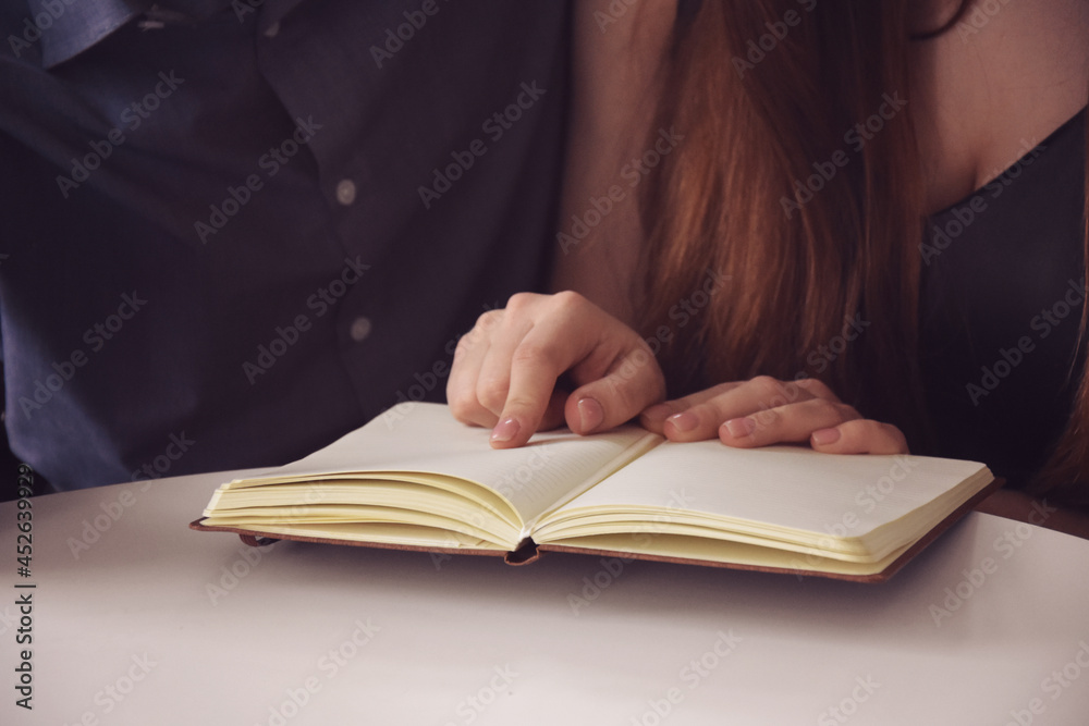 Happy couple reading book together in cozy flat Happy couple reading book together in cozy flat