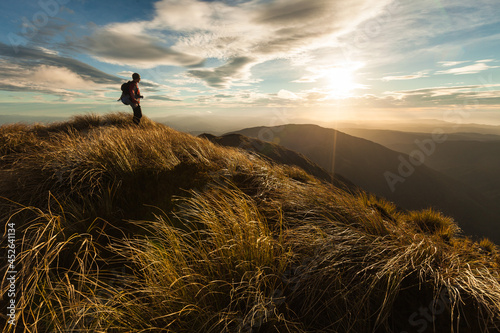 Tableau sur toile Female hiker standing on a ridge top at sunset, Southern Crossing, Tararua Fores