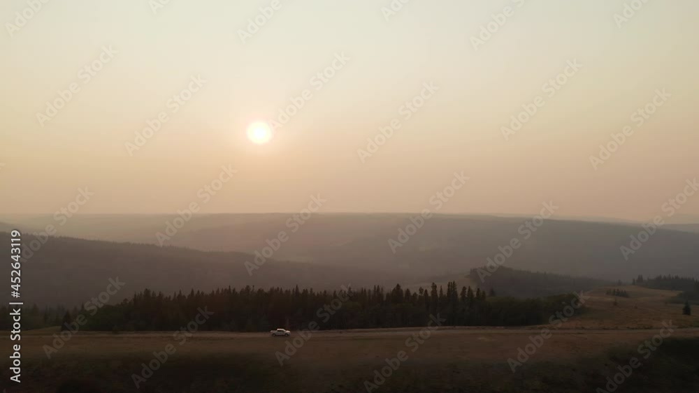 Truck drives mountain road through wildfire smoke in Canada. Aerial zoom out Truck drives mountain road through wildfire smoke in Canada. Aerial zoom out
