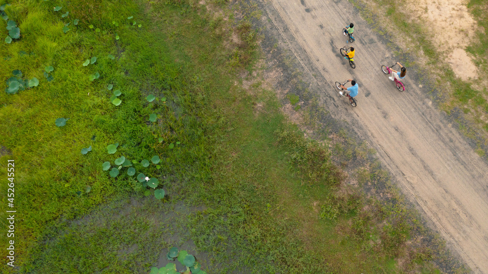 Happy family cycling on bikes outdoors, active parents with children have fun, family sport and fitness, aerial view from above Happy family cycling on bikes outdoors, active parents with children have fun, family sport and fitness, aerial view from above
