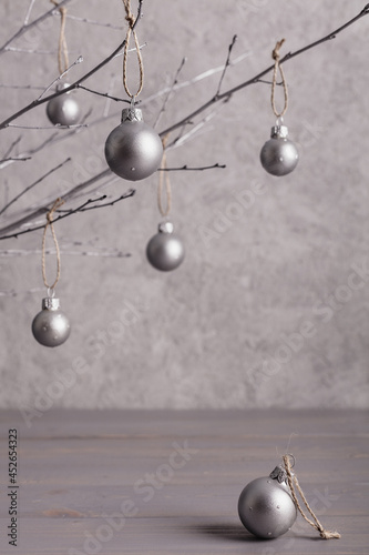 Merry Christmas! Christmas concept, minimalism. Branches of trees with Christmas tree decorations on a gray background of a silver color.