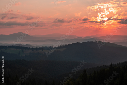 a landscape with sunset and fog in the mountains