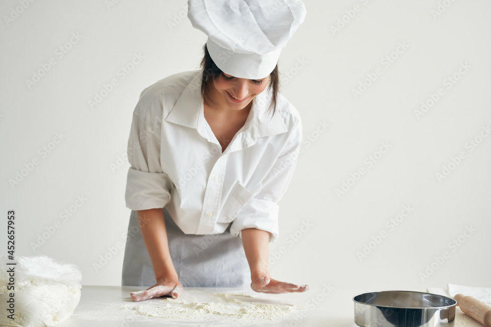 woman baker in chef uniform rolls out dough flour professional cooking woman baker in chef uniform rolls out dough flour professional cooking