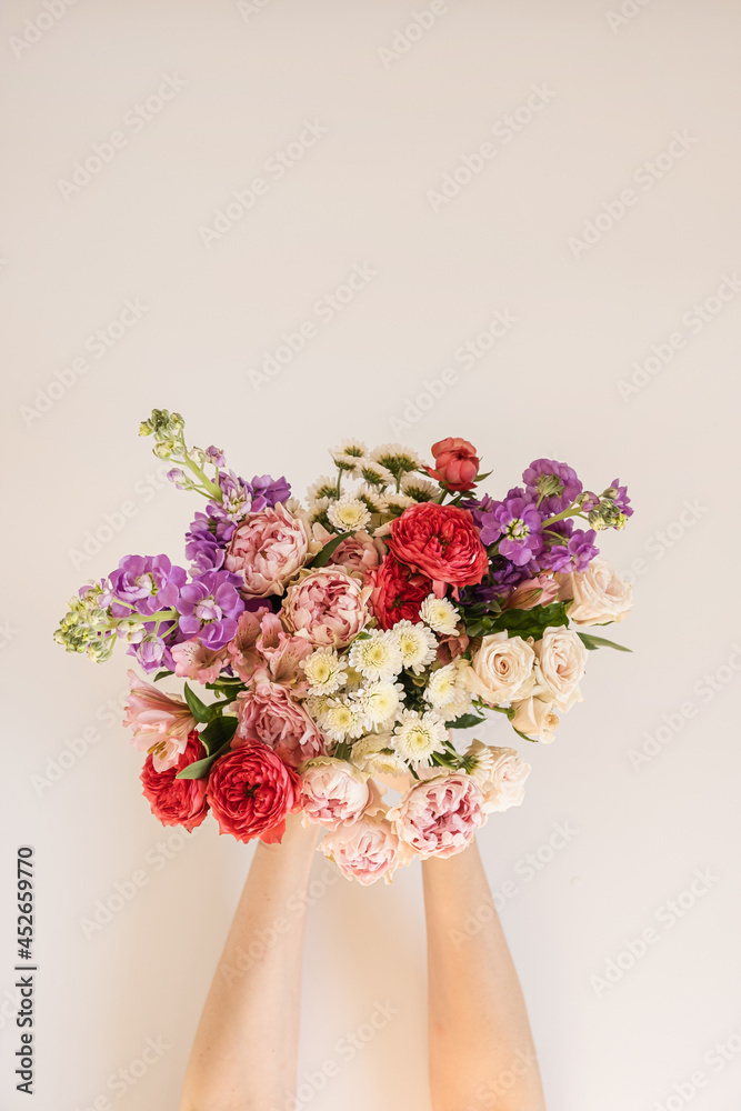 Abstract aesthetic floral background. Beautiful colourful flowers bouquet  in female hands on white background. Beautiful flowers and petals  composition Stock Photo | Adobe Stock
