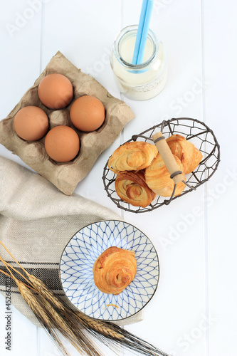 Mini Croissant with Milk, Flaky Pastry with Butter from French. Served on Plate and Woven Wire Basket on White Kitchen.