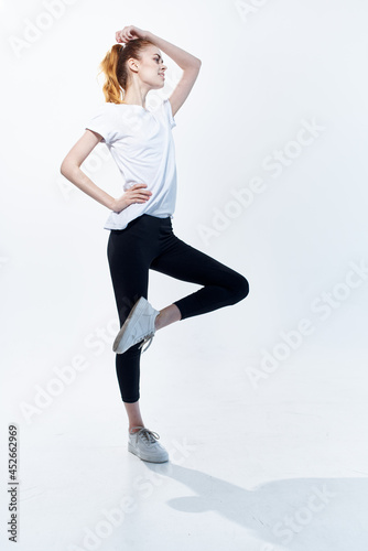 pretty woman in white t-shirt energy jumping port light background