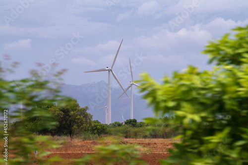 Windmill - Wind turbine below the mountain on the agriculture land. Alternate energy source generator with environment friendly. Wind turbines for ecological power supply .. © ManojKumar