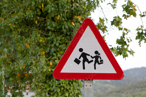 señal de tráfio advirtiendo de peligro por zona escolar photo