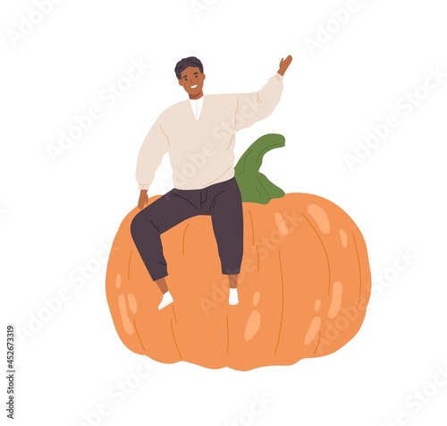 Happy tiny person sitting on huge fresh pumpkin. Smiling man with big autumn ...
