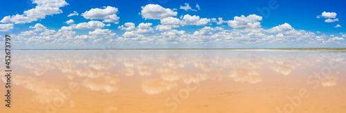 amazing panorama of Lake Elton on a summer day, beautiful sky with clouds and its reflection in the water.