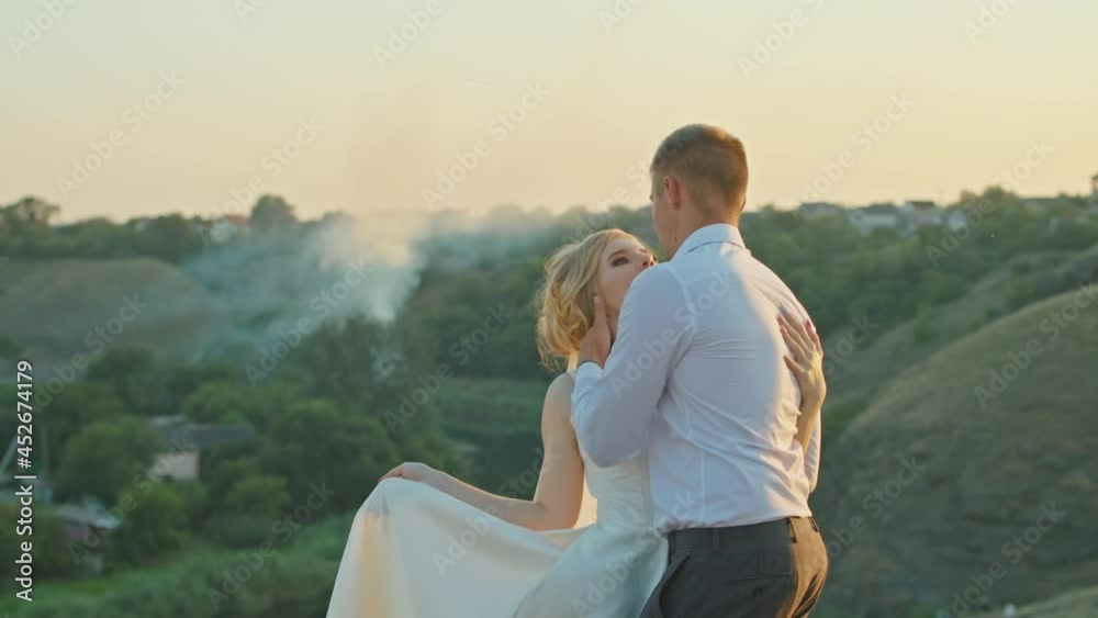 Wedding couple having fun at sunset on a rock near the river Wedding couple having fun at sunset on a rock near the river