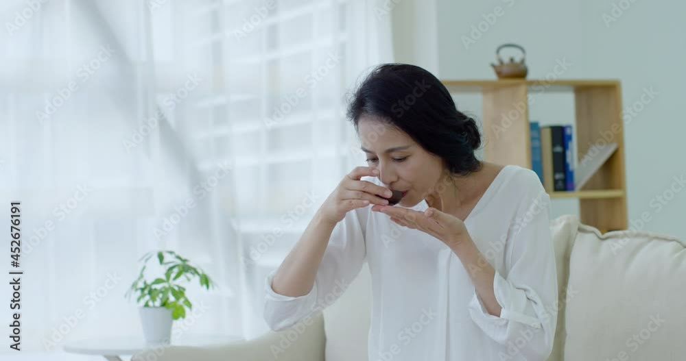 Happy mature woman drinking tea in living room,4K Happy mature woman drinking tea in living room,4K