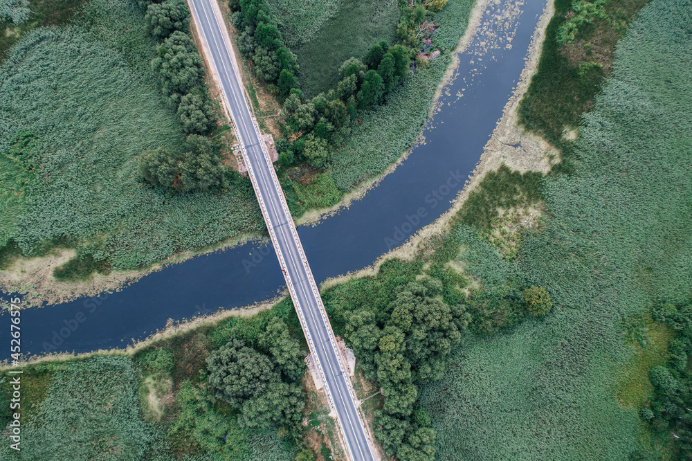 The road in the village crosses the river, shot from above