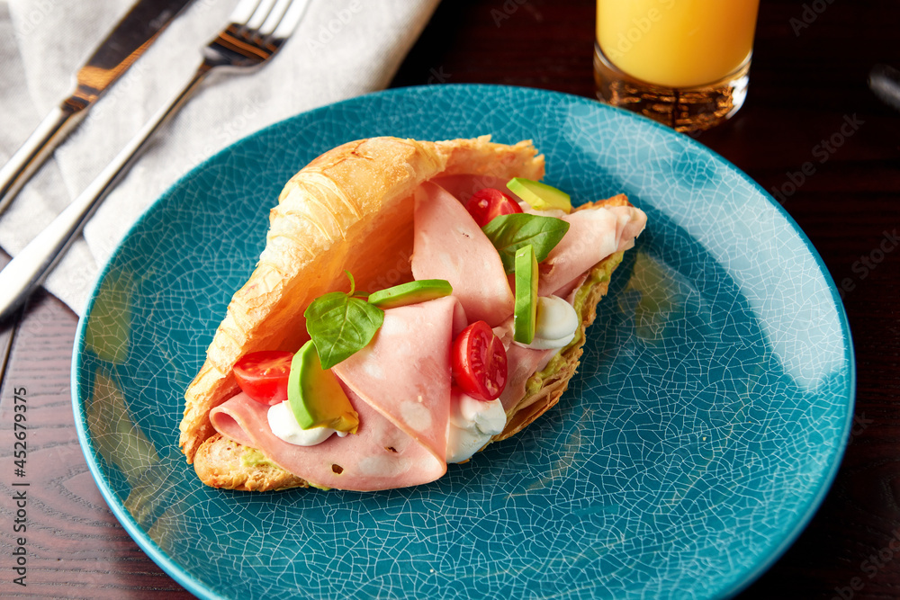 Croissant with mortadella sausage and cream cheese. Stock Photo Adobe