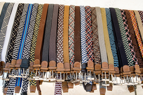 Multi-colored belts hung at a weekly street market