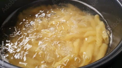 Boiling water with pasta in the pot. Preparation of pasta in hot water, 4K resolution.