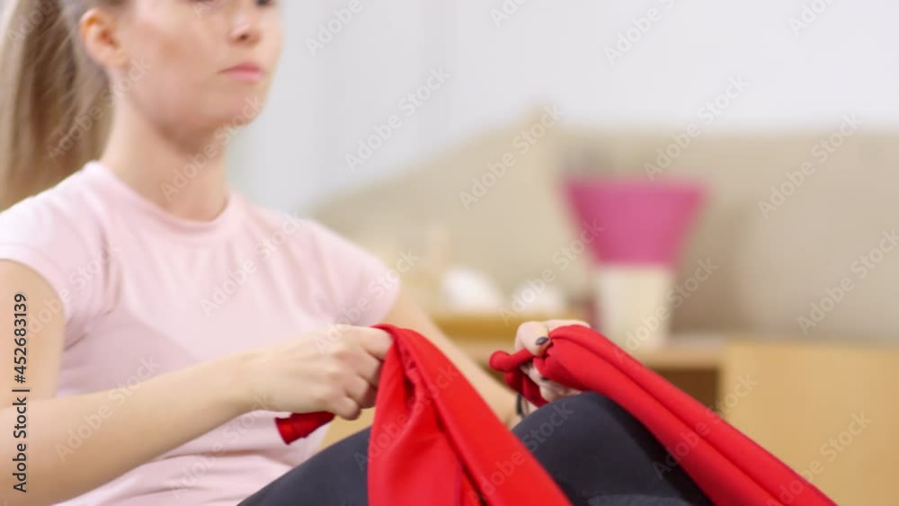 Close up tilt down shot of young woman in sportswear doing sit ups with resistance band while working out at home Close up tilt down shot of young woman in sportswear doing sit ups with resistance band while working out at home