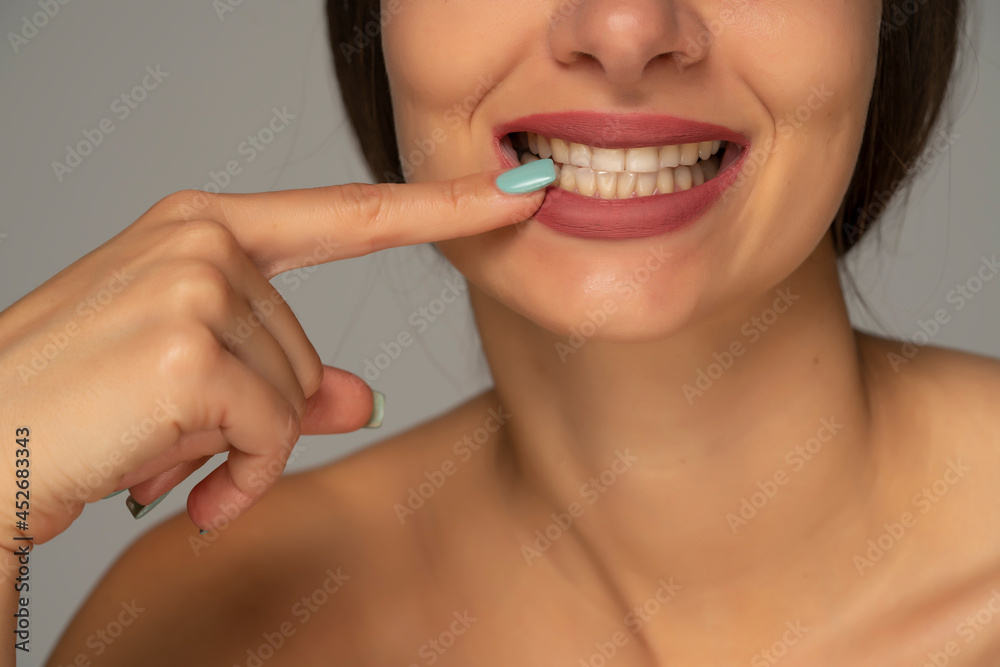 pointing on her healthy white teeth pointing on her healthy white teeth