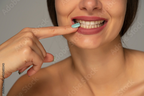 pointing on her healthy white teeth