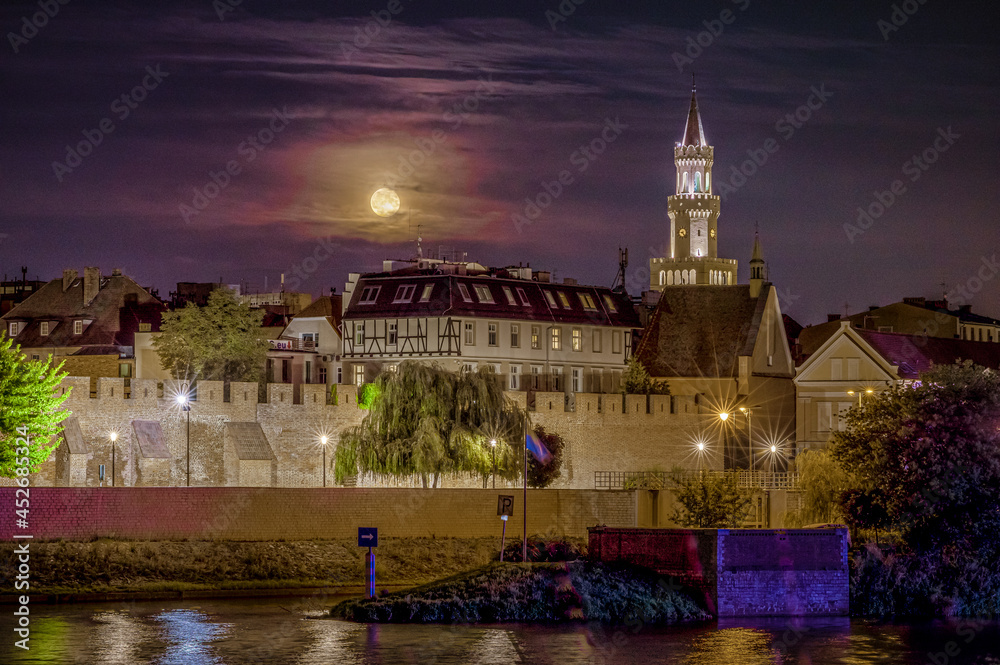 Opole z murami miejskimi i ratuszem w nocy podczas pełni księżyca