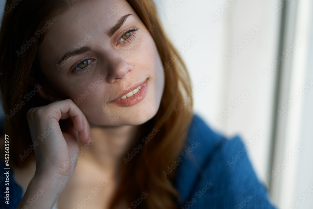 pretty woman sitting on the windowsill with a blue plaid dreamy look pretty woman sitting on the windowsill with a blue plaid dreamy look