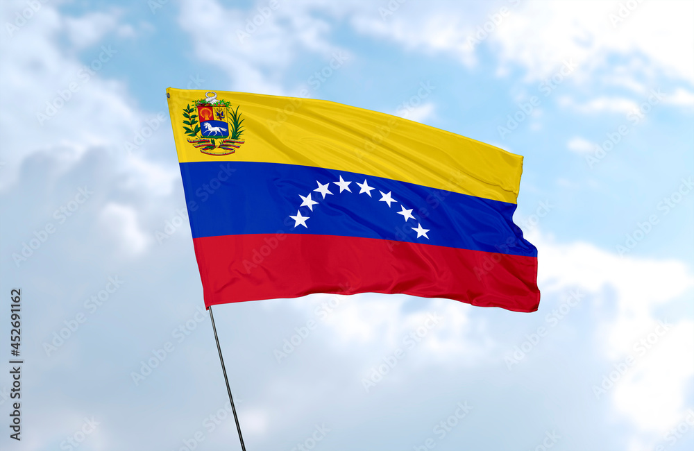 Flag of Venezuela, realistic 3d rendering in front of blue sky Flag of Venezuela, realistic 3d rendering in front of blue sky