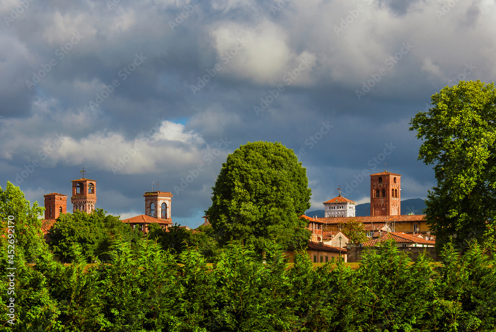 Lucca charming historic center skyline with medieval towers rises above surrounding anciet walls park trees