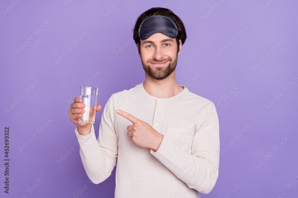 Photo of positive person indicate finger hand hold water cup look camera isolated on purple color background Photo of positive person indicate finger hand hold water cup look camera isolated on purple color background