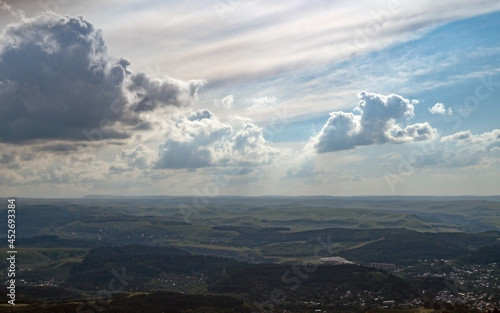 Landscape with clouds and a valley. View from the mountain to the plain.