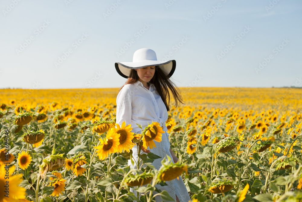 woman in a hat in a field of sunflowers