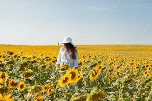 woman in a hat in a field of sunflowers