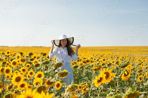 woman in a hat in a field of sunflowers