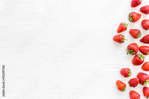Flat lay of ripe strawberries with green leaves