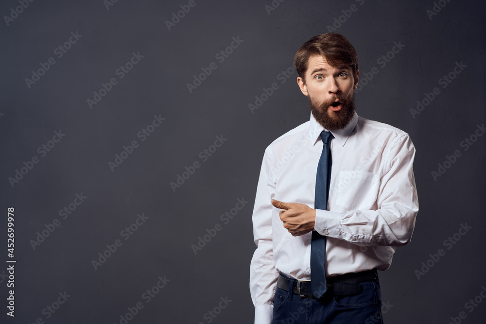 The man in a suit in a white shirt pulls the tie dark background The man in a suit in a white shirt pulls the tie dark background