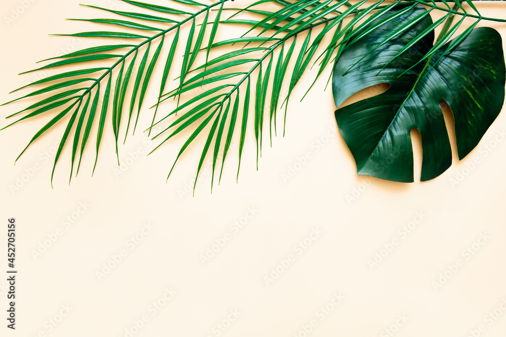 Mock up of green leaves of a palm tree on a beige background. Flat lay. Minimalistic summer concept with tropical tree leaves.	