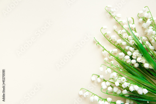Bouquet of white lilies of the valley on a beige background. Floral layout, template. Copy space. Artificial flowers.