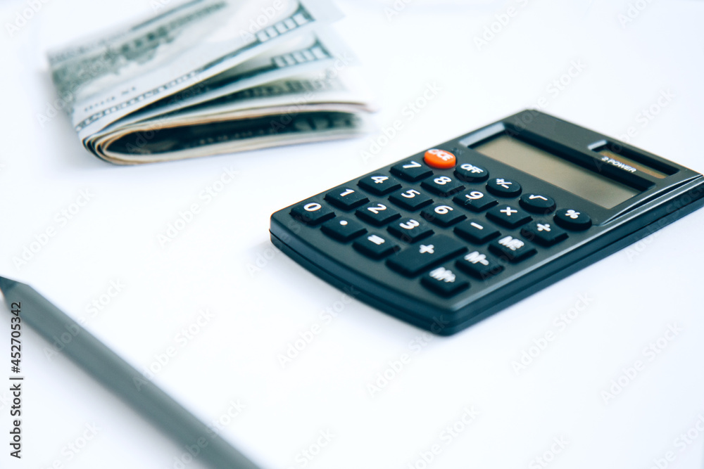 Calculator and paper money isolated on white background with copy space. Concept of keeping money, investing Calculator and paper money isolated on white background with copy space. Concept of keeping money, investing