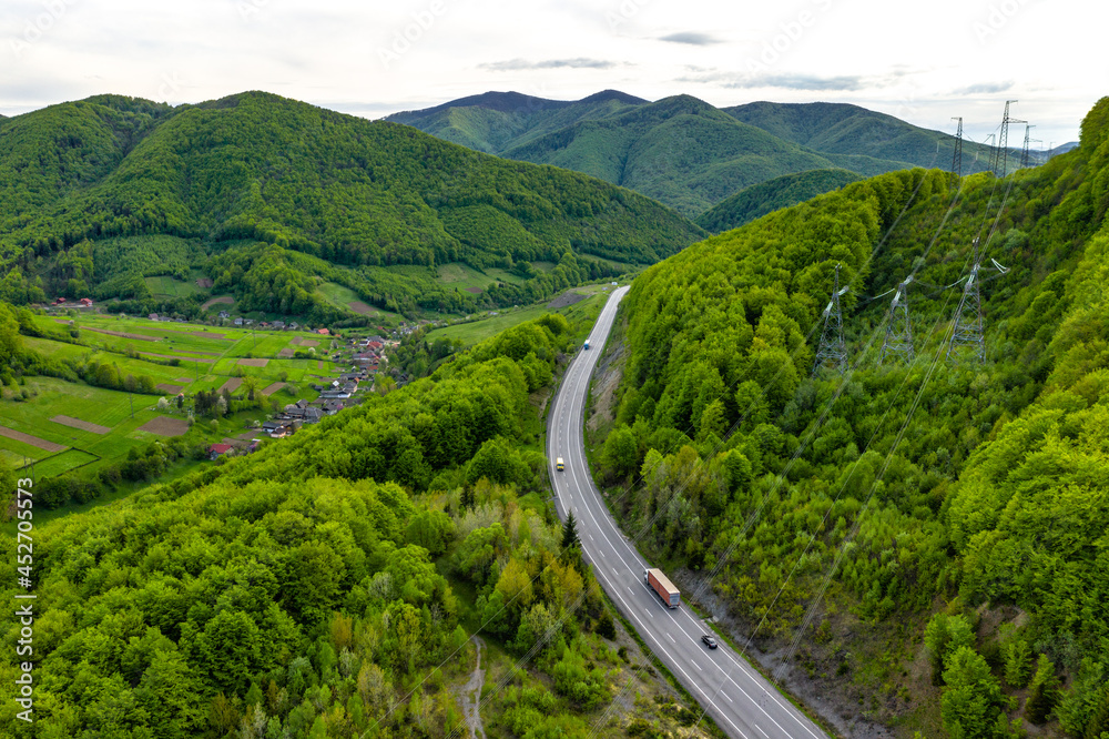 Car traffic in mountains who covered with beautiful green trees aerial panorama view