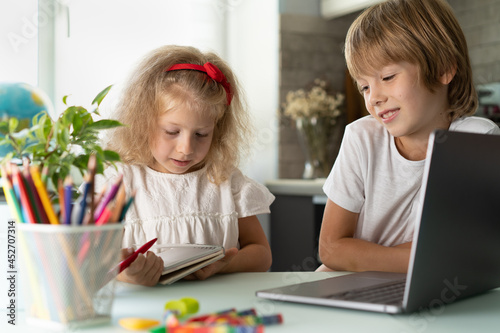 brother and sister study at home at laptop, children and gadgets