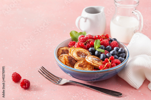 mini pancake breakfast bowl with berries and maple syrup