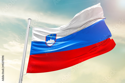 Slovenia national flag waving in beautiful clouds.